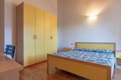 a bedroom with a bed and yellow cabinets at Appartamento al Sol Grauno Ospitar in Grauno