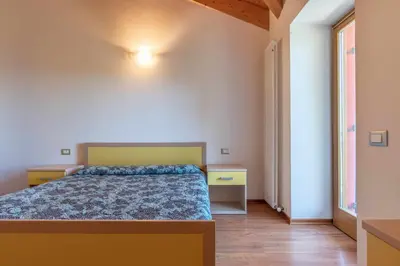 a bedroom with a bed and a large window at Appartamento al Sol Grauno Ospitar in Grauno