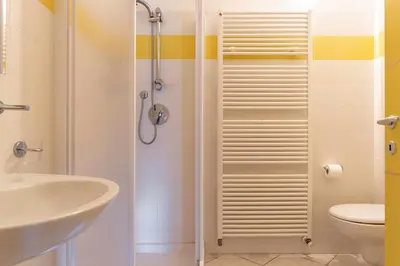 a bathroom with a shower and a sink and a toilet at Appartamento al Sol Grauno Ospitar in Grauno