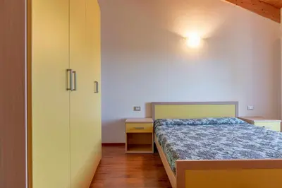 a small bedroom with a bed and a cabinet at Appartamento al Sol Grauno Ospitar in Grauno