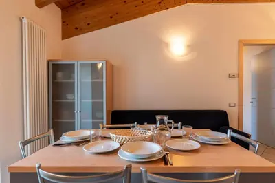 a dining room table with chairs and a wooden tableablish at Appartamento al Rio Grauno Ospitar in Grauno