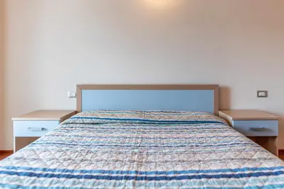 a bedroom with a bed with two nightstands at Appartamento al Rio Grauno Ospitar in Grauno