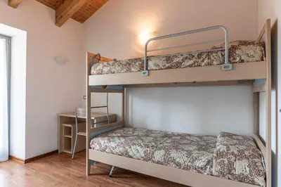 a bedroom with two bunk beds and a desk at Appartamento al Rio Grauno Ospitar in Grauno