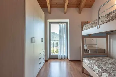 a bedroom with a bunk bed and a staircase at Appartamento al Rio Grauno Ospitar in Grauno