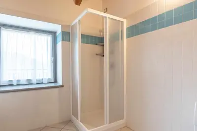 a shower with a glass door in a bathroom at Appartamento al Rio Grauno Ospitar in Grauno