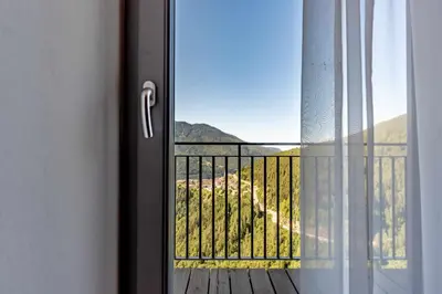 a sliding glass door with a view of a balcony at Appartamento al Rio Grauno Ospitar in Grauno