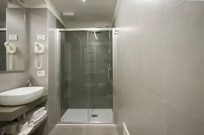 a bathroom with a glass shower and a sink at Hotel Venezia in Rocca Pietore