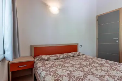a small bedroom with a bed and a closet at Appartamento alla Preda Grauno Ospitar in Grauno