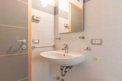 a bathroom with a sink and a mirror at Appartamento alla Preda Grauno Ospitar in Grauno