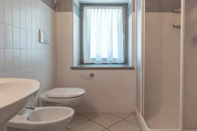 a bathroom with a toilet and a sink and a shower at Appartamento alla Preda Grauno Ospitar in Grauno