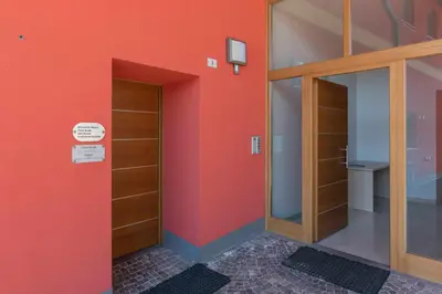 a room with orange walls and wooden shelves at Appartamento alla Preda Grauno Ospitar in Grauno