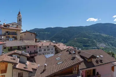 a group of buildings with mountains in the background at Appartamento alla Preda Grauno Ospitar in Grauno