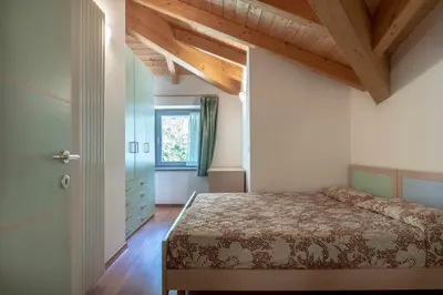 a bedroom with a bed and a wooden ceiling at Appartamento al Bosc Grauno Ospitar in Grauno
