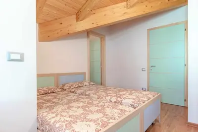 a bedroom with a bed and a wooden ceiling at Appartamento al Bosc Grauno Ospitar in Grauno