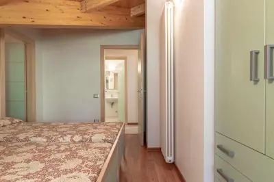a bedroom with a bed and a hallway with a door at Appartamento al Bosc Grauno Ospitar in Grauno