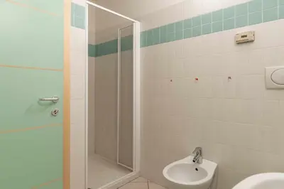 a bathroom with a shower and a toilet and a sink at Appartamento al Bosc Grauno Ospitar in Grauno