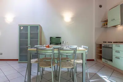 a kitchen with a table with chairs and a laptop on it at Appartamento al Bosc Grauno Ospitar in Grauno