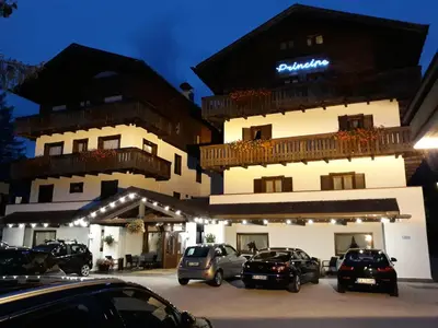a snow covered street in front of a lodge at Hotel Principe in Cortina dʼAmpezzo