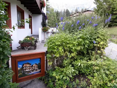 a bedroom with a bed and a door with a rug at Hotel Principe in Cortina dʼAmpezzo