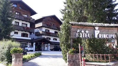 a hotel with lights on it in the snow at Hotel Principe in Cortina dʼAmpezzo