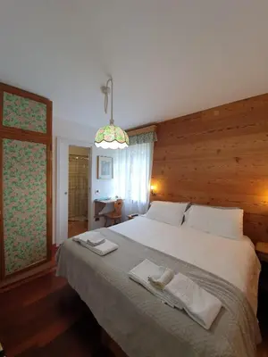 a bedroom with a large bed with towels on it at B&B Cristallo in Cortina dʼAmpezzo