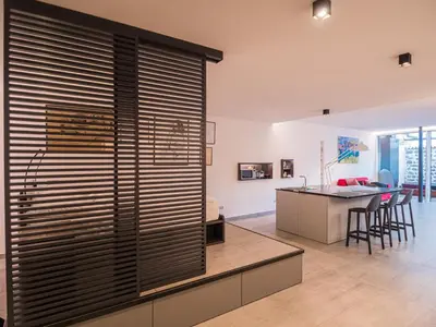 a kitchen with a large window with wooden blinds at Sweet Piccolo in Merano