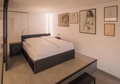 a bed in a room with pictures on the wall at Sweet Piccolo in Merano