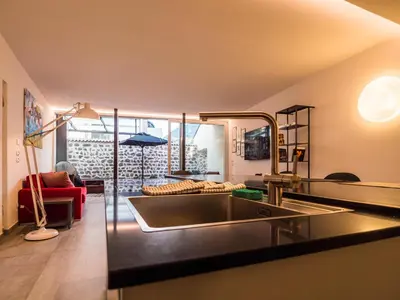 a kitchen with a sink and a living room at Sweet Piccolo in Merano