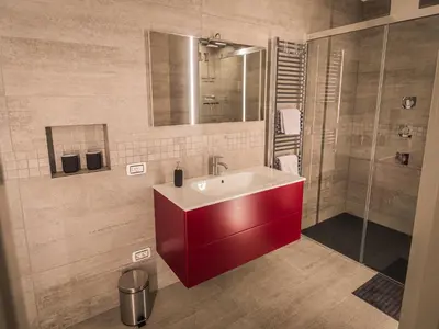 a bathroom with a red sink and a shower at Sweet Piccolo in Merano