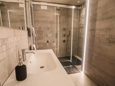 a bathroom with a shower and a white sink at Sweet Piccolo in Merano