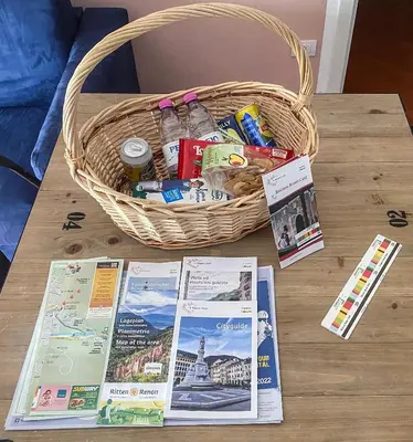 a basket sitting on a table with magazines and leaflets at Living Rencio: vicino al Centro di Bolzano in Bolzano