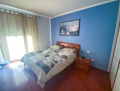 a blue bedroom with a bed and a window at Living Rencio: vicino al Centro di Bolzano in Bolzano