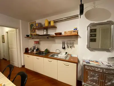 a kitchen with white cabinets and a sink at Living Rencio: vicino al Centro di Bolzano in Bolzano