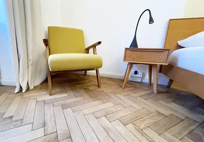 a bedroom with a chair and a bed and a desk at Rosa Apartments City Center in Merano