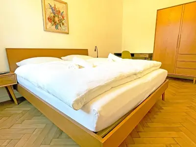 a large bed with white sheets and pillows at Rosa Apartments City Center in Merano