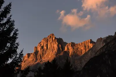 a view of a mountain with the sun shining on it at Residence Peniè in San Vito di Cadore