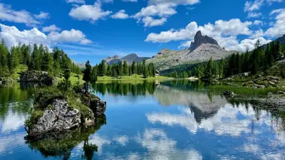 a mountain reflected in a lake in the mountains at Residence Peniè in San Vito di Cadore