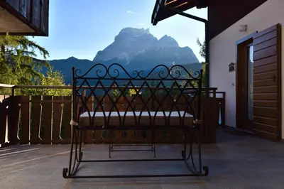 a bench on a porch with a view of a mountain at Residence Peniè in San Vito di Cadore