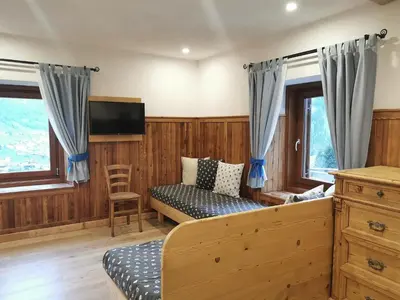 a living room with a couch and a tv at Cesa da Riz in Colle Santa Lucia
