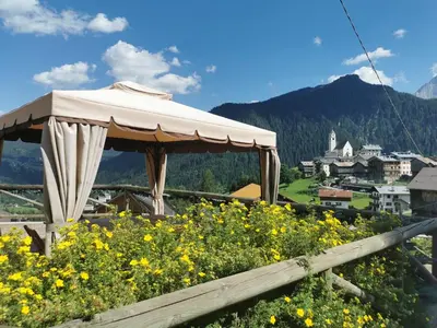 a gazebo sitting on top of a field of flowers at Cesa da Riz in Colle Santa Lucia
