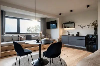a living room with a table and chairs and a couch at My Spring - Panoramic Suites in Lana