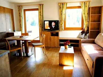 a living room with a couch and a table at Lü de Rü in San Vigilio Di Marebbe