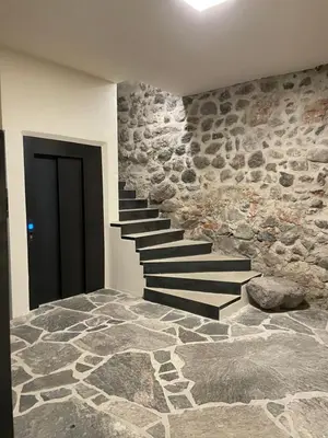 a stone staircase in a room with a stone wall at Rosa's Boutique Apartment in Merano