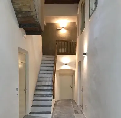 a staircase leading up to a white building with a door at Rosa's Boutique Apartment in Merano