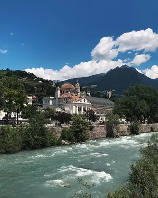a view of a river with a town in the background at Rosa's Boutique Apartment in Merano