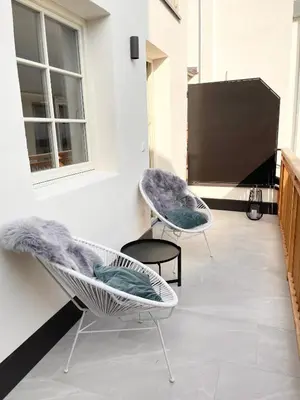 two chairs sitting on a patio with a tv at Rosa's Boutique Apartment in Merano
