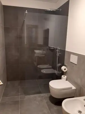 a bathroom with two sinks and a toilet and a shower at Appartments Lindenhof in Riscone