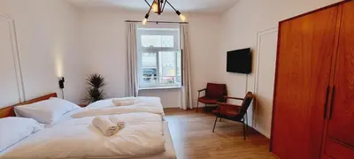 a hotel room with two beds and a window at Rosa Rooms Meran in Merano