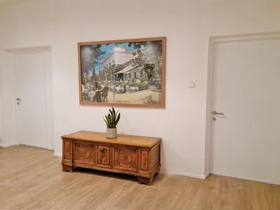 a room with a painting on the wall and a wooden table at Rosa Rooms Meran in Merano