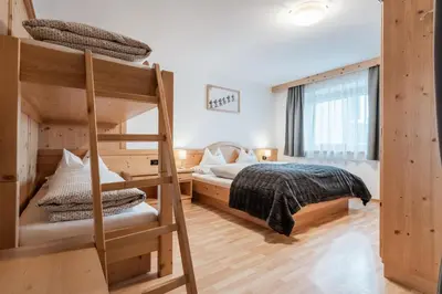 a bedroom with two bunk beds and a ladder at La ciasota in Antermoia